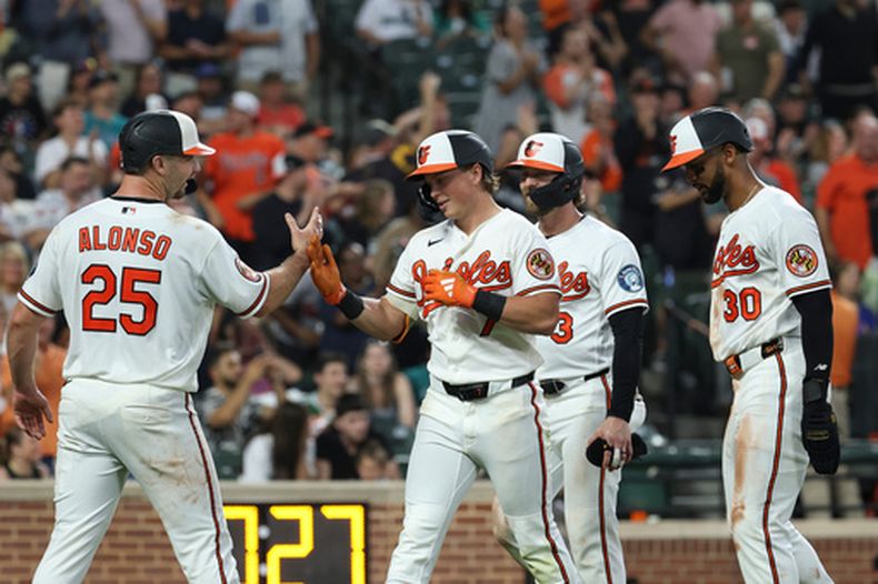 Jackson Holliday, centro, de los Orioles de Baltimore, celebra su grand slam con Pete Alonso (25) frente a Domingo Gonzalez, de los Mariners de Seattle, que remolcó a Taylor Ward, Pete Alonso y Leody Taveras, durante la séptima entrada del juego de béisbol de Grandes Ligas del miércoles 10 de junio de 2026, en Baltimore. (AP Foto/Terrance Williams)