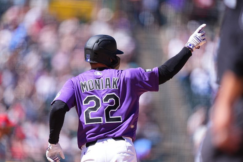 Mickey Moniak, de los Rockies de Colorado, gesticula hacia el bullpen mientras recorre las bases tras conectar un jonrón solitario ante Taijuan Walker, de los Filis de Filadelfia, en la quinta entrada de un juego de béisbol el domingo 5 de abril de 2026, en Denver. (Foto AP/David Zalubowski)
