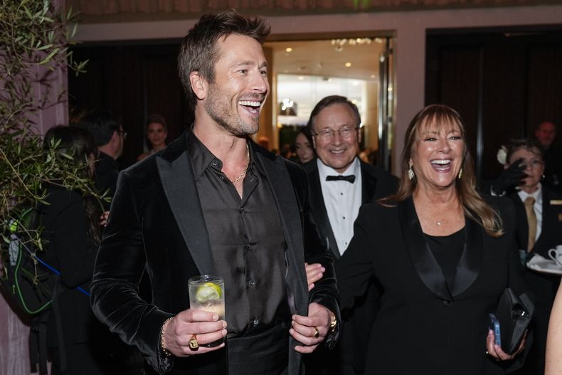 Glen Powell, izquierda, y Cyndy Powell llegan a la 82ª edición de los Globos de Oro el domingo 5 de enero de 2025 en el Beverly Hilton de Beverly Hills, California. (Foto AP/Chris Pizzello)