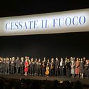 Miembros de la compañía de danza y de la orquesta de La Scala se mantienen de pie en el escenario antes de la última presentación de la ópera-ballet Madina, el sábado 9 de marzo de 2024, en Milán, Italia. La pancarta encima de ellos dice: Alto al fuego. (AP Foto/Colleen Barry)