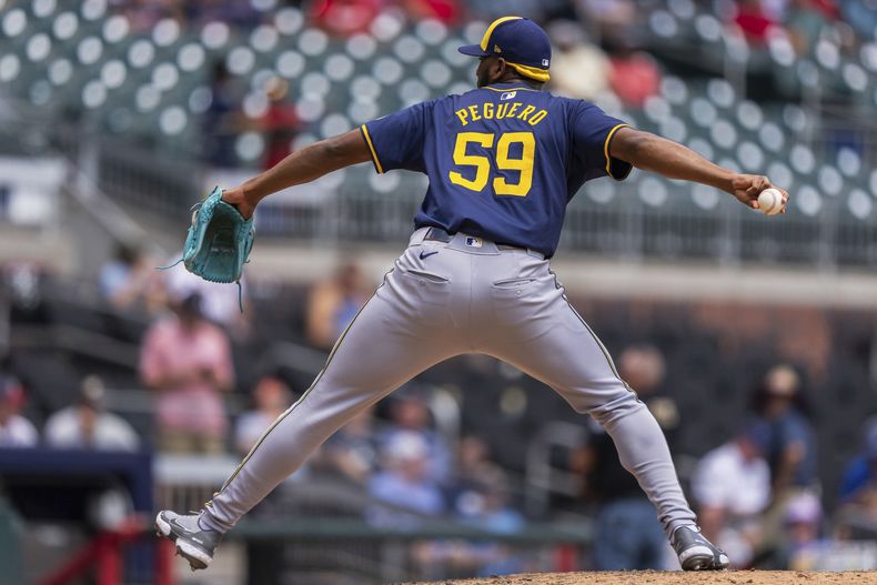 El dominicano Elvis Peguero, de los Cerveceros de Milwaukee, lanza en la quinta entrada del juego ante los Bravos de Atlanta, el jueves 8 de agosto de 2024 (AP Foto/Jason Allen)
