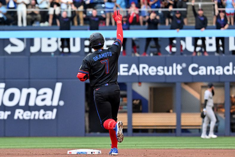 El jugador de cuadro de los Azulejos de Toronto, Kazuma Okamoto (7), hace un gesto hacia el bullpen tras conectar un jonrón de dos carreras que impulsó a Alejandro Kirk (no aparece en la foto) contra los Yankees de Nueva York, durante la primera entrada de un partido de béisbol en Toronto, el viernes 12 de junio de 2026. (Jon Blacker/The Canadian Press vía AP)