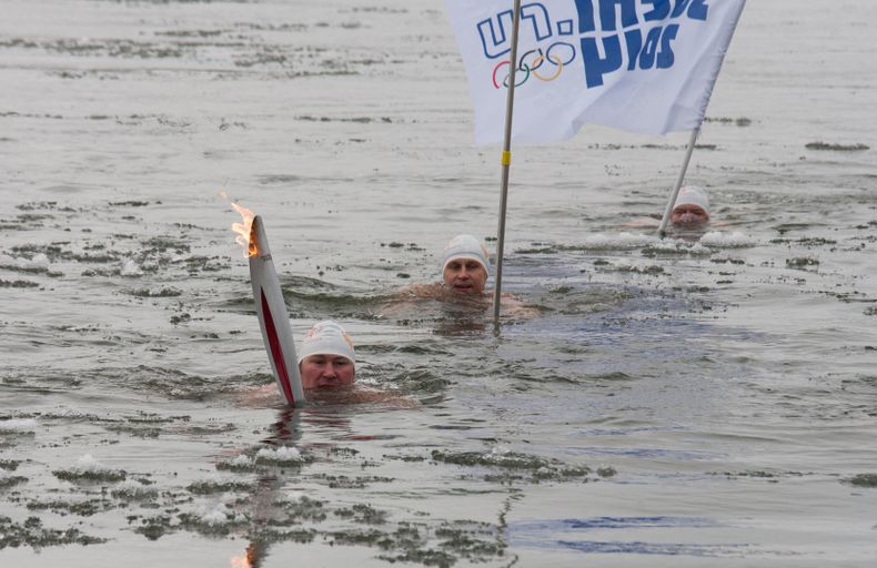 Alexander Brylin, izquierda, nada con la antorcha ol&iacute;mpica de los Juegos de Invierno de sochi el martes, 19 de noviembre de 2013, en el r&iacute;o Amur en Blagoveshchensk, Rusia. Foto suministrada por Olympictorch2014.com.  (AP Photo/Olympictorch20