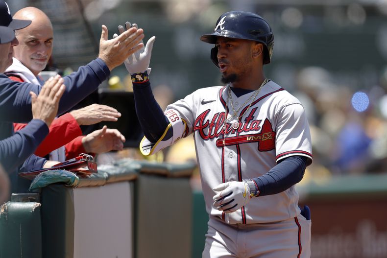 Ozzie Albies, de los Atléticos de Oakland, es felicitado por sus compañeros tras conectr un jonrón ante los Atléticos de Oakland, el martes 31 de mayo de 2023 (AP Foto/Jed Jacobsohn)