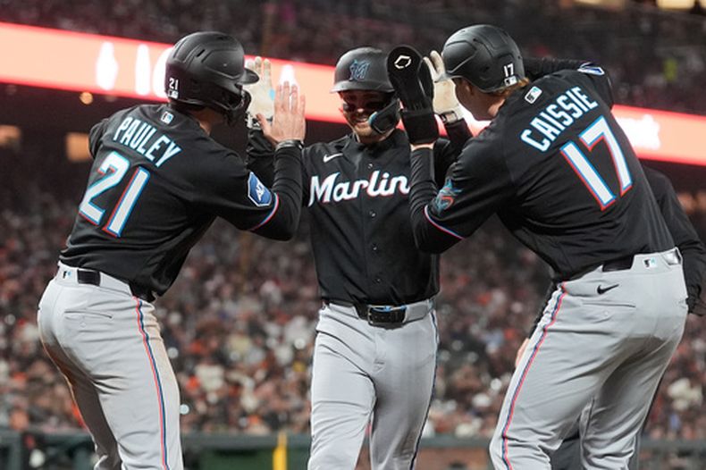Connor Norby, al centro, de los Marlins de Miami, celebra después de batear cuadrangular de tres carreras, con el que también anotaron Graham Pauley (21) y Owen Caissie (17) durante la cuarta entrada del juego de béisbol de Grandes Ligas contra los Gigantes de San Francisco el viernes 24 de abril de 2026, en San Francisco. (AP Foto/Jeff Chiu)