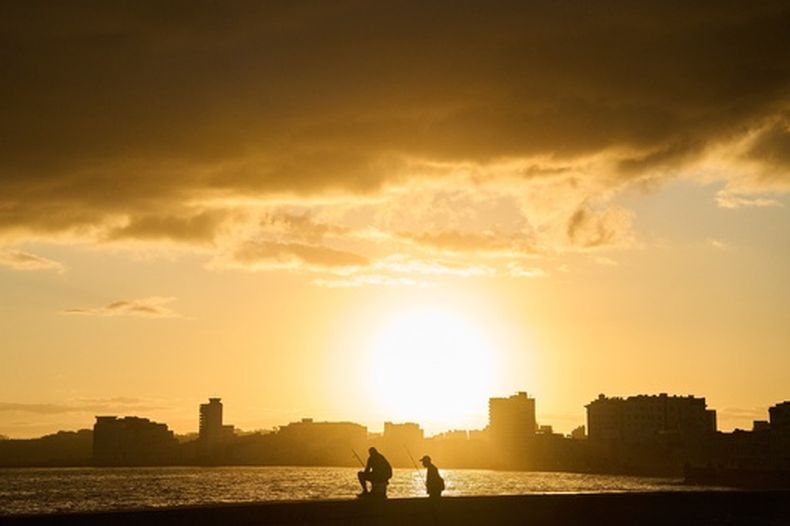 Dos hombres pescan en el Malecón al amanecer durante un apagón en La Habana, Cuba, el domingo 22 de marzo de 2026. (Foto AP/Ramon Espinosa)