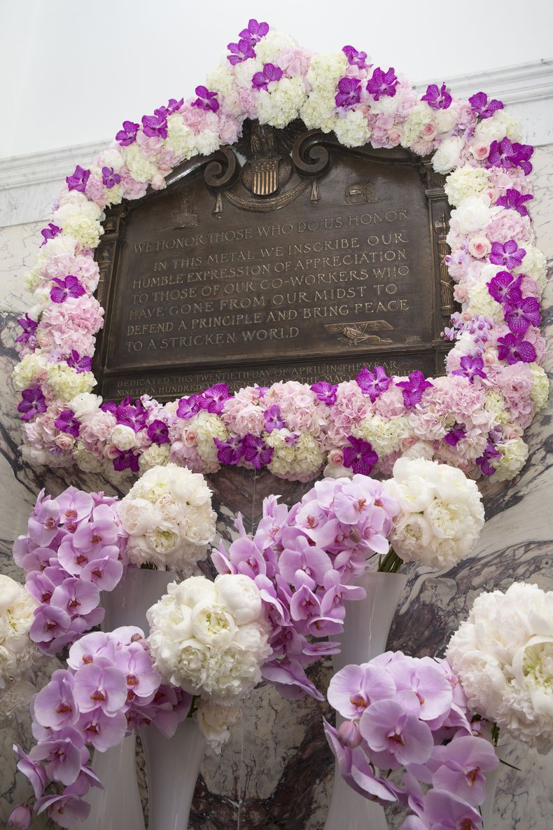 ARCHIVO - Un arreglo de flores adorna la placa en memoria de Isidor y Ida Straus durante una ceremonia en la tienda insignia de Macys en Nueva York, el jueves 29 de mayo de 2014. (AP Foto/John Minchillo, Archivo)