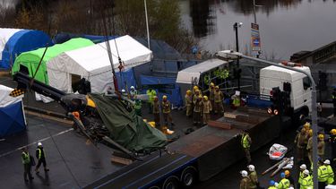americateve | Personal de bomberos obsreva c&oacute;mo un helic&oacute;ptero accidentado es elevado para colocar en un remolque despues que el aparato se precipit&oacute; sobre un bar de Glasgow con un saldo de 9 muertos, el lunes 2 de diciembre del 2013. (AP Foto)