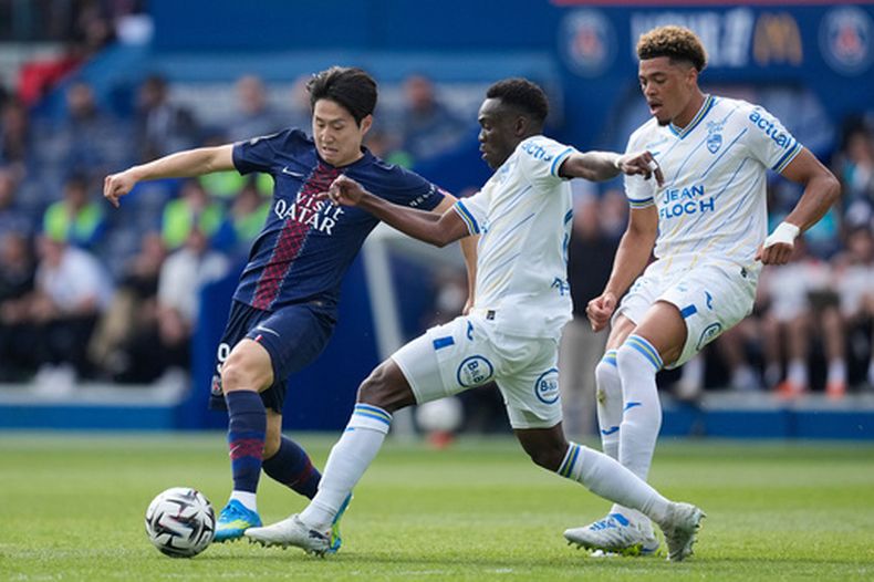 Lee Kang-in del Paris Saint-Germain pelea por el balón con Arthur Avom del Lorient en el encuentro de la liga francesa el sábado 2 de mayo del 2026. (AP Foto/Christophe Ena)