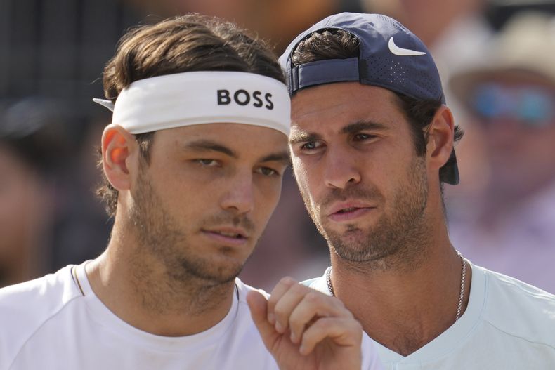 Karen Khachanov, habla con el estadounidense Taylor Fritz durante la final de dobles ante el británico Neal Skupskiand y el neozelandés Michael Venus en Queens Club el domingo 23 de junio del 2024. (AP Foto/Kin Cheung)