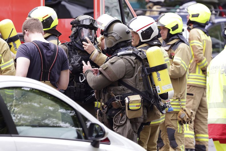 Bomberos y policías con máscaras de gas ante un edificio residencial en Ratingen, Alemania, el jueves 11 de mayo de 2023. (David Young/dpa via AP)