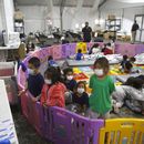 En esta imagen del 30 de marzo de 2021, migrantes menores sin compañía de un adulto ven televisión dentro de un corral de juegos en una instalación de la Oficina de Aduanas y Protección Fronteriza, el principal centro de detención para niños no acompañados en el Rio Grande Valley, en Donna, Texas. (AP Foto/Dario Lopez-Mills, Pool, Archivo)