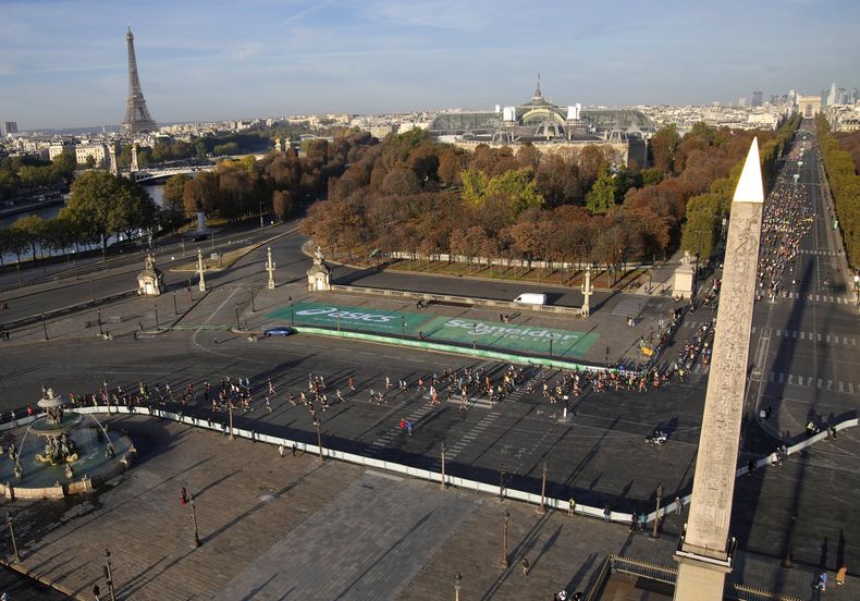 ARCHIVO - Los corredores pasan por la Plaza de la Concordia durante el Maratón de París, el 17 de octubre de 2021. La capital de Francia albergará dentro de un año los Juegos Olímpicos. (AP Foto/Christophe Ena)