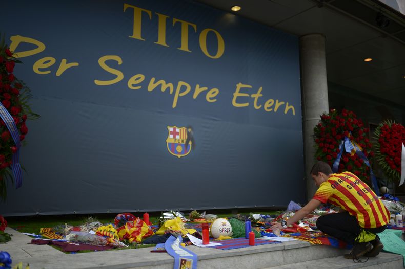 Un hombre coloca flores para rendir homenaje al fenecido ex t&eacute;cnico del Barcelona, Tito Vilanova, el viernes, 25 de abril de 2014, frente al estadio Camp Nou de Barcelona. (AP Photo/Manu Fernandez)