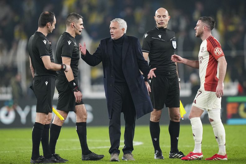 El técnico de Fenerbahce José Mourinho (centro) discute con el árbitro Simone Sozza (segundo desde la izquierda) al final del partido contra Lyon en la Liga Europa, el jueves 23 de enero de 2025, en Estambul. (AP Foto/Francisco Seco)