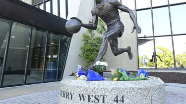 La foto del miércoles 12 de junio de 2024 muestra las ofrendas florales colocadas en la estatua de Jerry West en el Coliseum de Morgantown, Virginia Occidental (William Wotring/The Dominion-Post via AP)