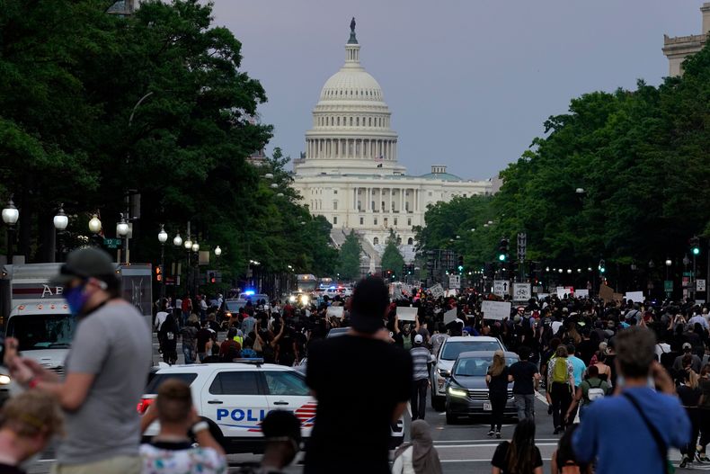 ARCHIVO - Manifestantes caminan por la avenida Pennsylvania para protestar por la muerte de George Floyd, el 29 de mayo de 2020, en Washington. (AP Foto/Evan Vucci/Archivo)