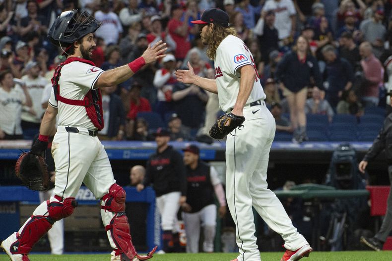 El receptor de los Guardianes de Cleveland, Austin Hedges, a la izquierda, felicita al relevista Scott Barlow al final de un juego de béisbol contra los Angelinos de Los Ángeles en Cleveland, el sábado 4 de mayo de 2024. (AP Foto/Phil Long)