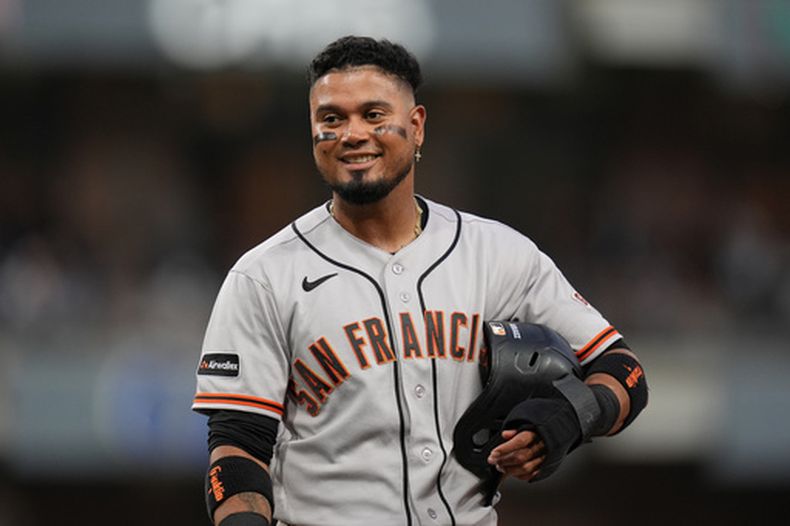Luis Arraez, de los Gigantes de San Francisco, bromea con jugadores en la cueva de los Padres de San Diego mientras se encuentra en la primera base tras ser golpeado por un lanzamiento durante la cuarta entrada de un partido de béisbol el jueves 30 de julio de 2026, en San Diego. (Foto AP/Gregory Bull)