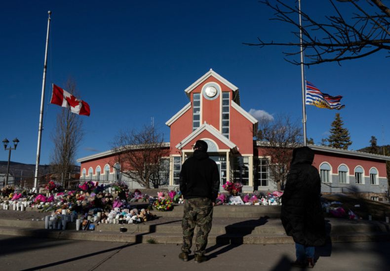 Personas rinden tributo a víctimas de un tiroteo, en la sede de la municipalidad de Tumbler Ridge, Columbia Británica, Canadá, el 14 de febrero del 2026. (Christinne Muschi/The Canadian Press via AP)