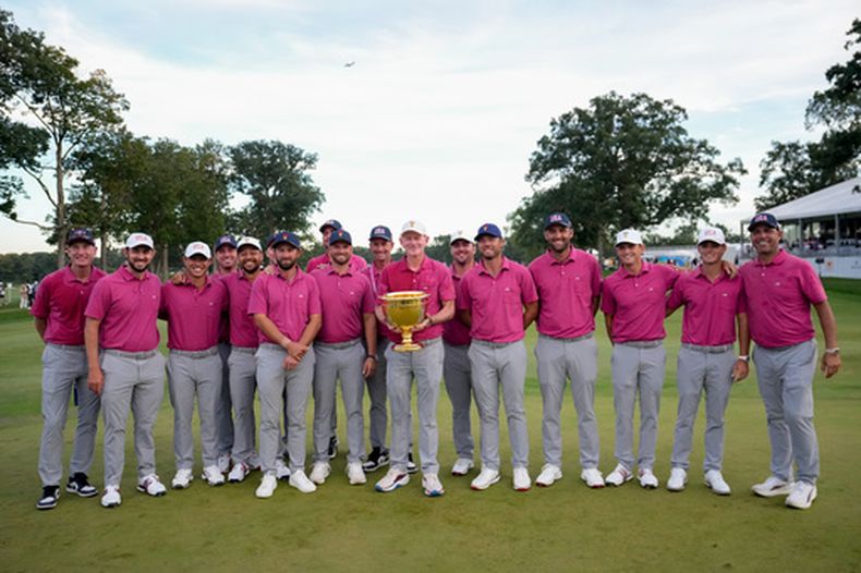 El capitán del equipo de EE. UU., Brandt Snedeker, sostiene el trofeo junto a su equipo mientras posan para una fotografía tras su victoria en el torneo de golf Presidents Cup frente al equipo Internacional en el Medinah Country Club, el domingo 27 de septiembre de 2026, en Medinah, Illinois. (Foto AP/Matt Slocum)