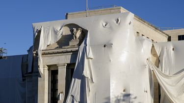 ARCHIVO - La escultura de un águila se observa entre la envoltura protectora de la fachada del edificio de la Junta de la Reserva Federal, que se somete a renovaciones interiores y exteriores, en Washington, el lunes 23 de octubre de 2023. (AP Foto/J. Scott Applewhite, archivo)