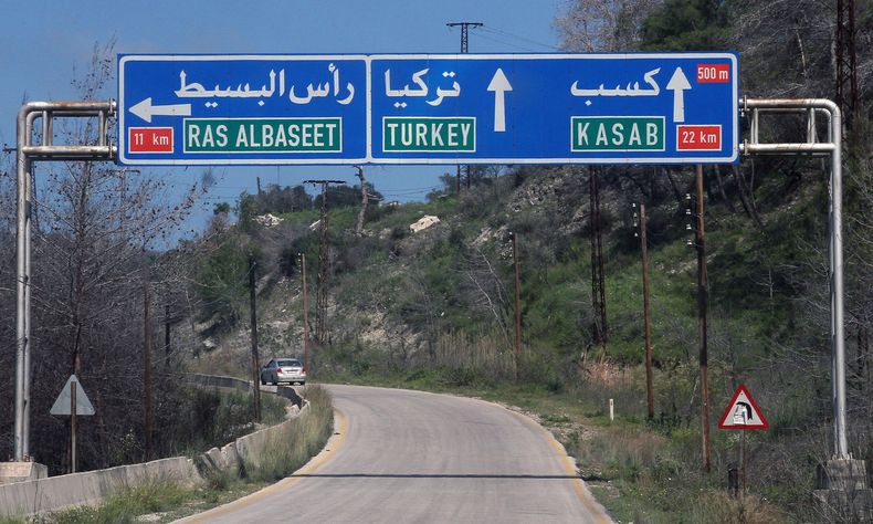 Un letrero indica que Turqu&iacute;a est&aacute; adelante en el camino durante un recorrido organizado por el gobierno de Siria para periodistas y realizado por soldados sirios, en la provincia de Latakia, el 27 de marzo de 2014. (Foto AP)