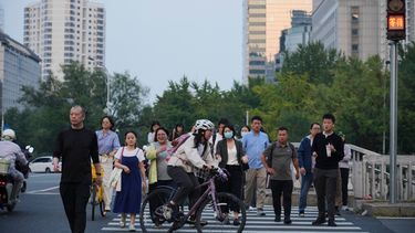 Un grupo de personas cruzan una intersección en Beijing, el lunes 28 de septiembre de 2026. (AP Foto/Achmad Ibrahim)