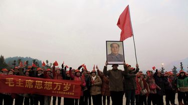 americateve | Unas personas ondean un cartel y sostienen una foto de Mao Tse-tung en Shaoshan, pueblo natal del l&iacute;der chino, en Hunan, en el sur de China, el 26 de diciembre de 2013, en conmemoraci&oacute;n de los 120 a&ntilde;os del nacimiento de Mao. (Foto AP)