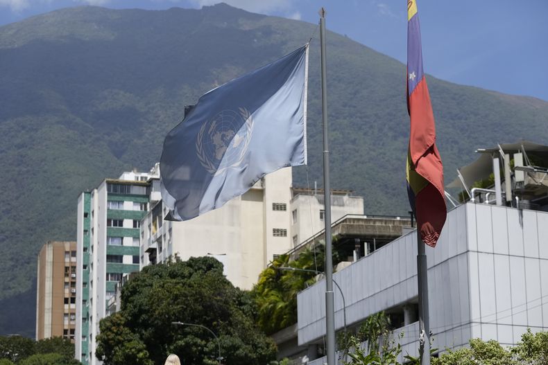 Una bandera de la ONU y de Venezuela cuelga afuera del edificio que alberga la Oficina de Asesoría Técnica del Alto Comisionado de las Naciones Unidas para los Derechos Humanos, en Caracas, Venezuela, el jueves 15 de febrero de 2024. El gobierno de Venezuela ordenó el jueves que esa oficina suspenda operaciones y dio a su personal 72 horas para salir del país. (AP Foto/Matias Delacroix)