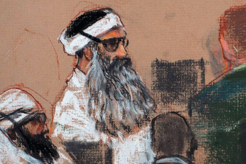 ARCHIVO - Este dibujo del lunes 8 de diciembre de 2008, realizado por la artista Janet Hamlin y revisado por las fuerzas armadas de Estados Unidos, muestra a Khalid Sheikh Mohammed, al centro, y a su cómplice Walid Bin Attash, izquierda, durante una sesión previa a un juicio en la Base Naval de Bahía de Guantánamo, Cuba. Khalid Sheikh Mohammed está acusado de ser el autor intelectual de los atentados del 11 de septiembre de 2001. (AP Foto/Janet Hamlin, foto compartida, archivo)