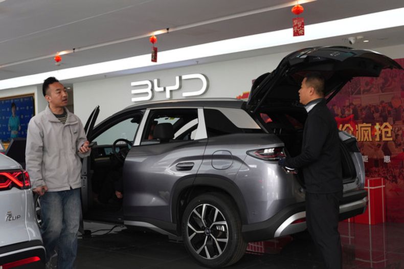 Visitantes observan un automóvil híbrido en una sala de exposición de BYD en Pekín, China, el jueves 26 de marzo de 2026. (Foto AP/Ng Han Guan)