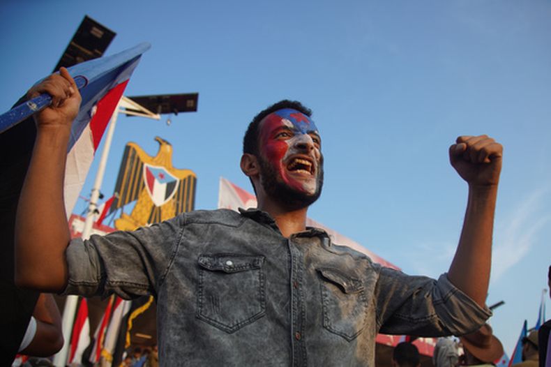 Un simpatizante del Consejo de Transición del Sur sostiene una bandera de Yemen en una manifestación para celebrar el 63er aniversario de la revolución del 14 de octubre contra el gobierno colonial británico y responder a los llamados ala movilización contra los rebeldes hutíes en Adén, Yemen, el miércoles 14 de octubre de 2026. (AP Foto/Abdulnasser Alseddik)