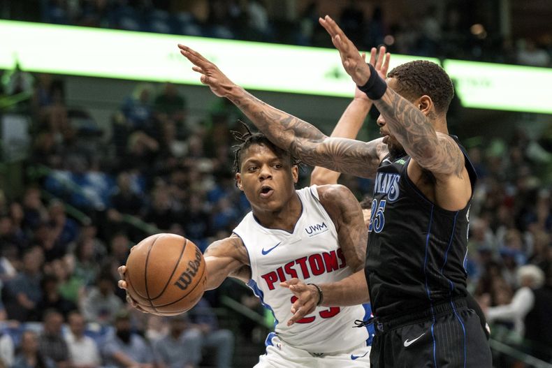 Marcus Sasser, base de los Pistons de Detroit, envía un pase frente a P.J. Washington, de los Mavericks de Dallas, el viernes 12 de abril de 2024 (AP Foto/Jeffrey McWhorter)
