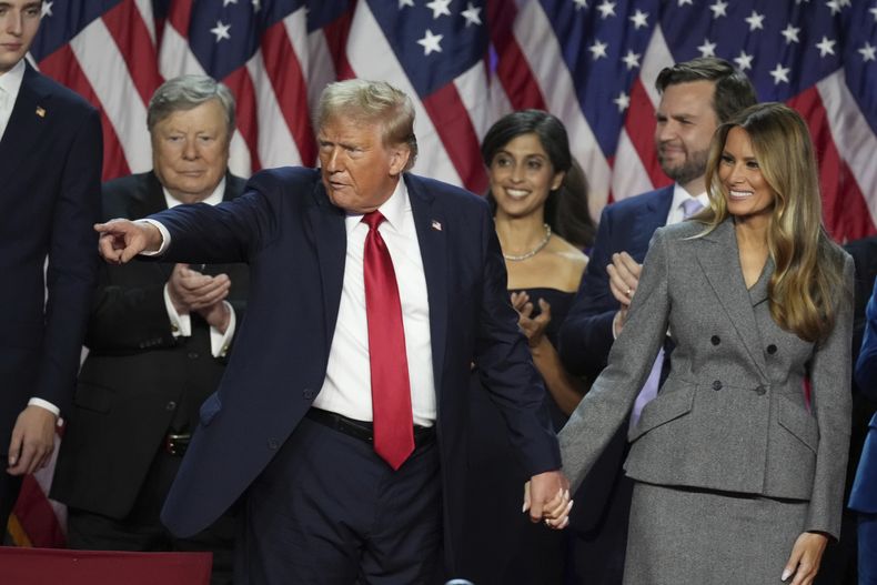 El candidato republicano a la presidencia, el expresidente Donald Trump, toma la mano de la ex primera dama Melania Trump luego de hablar con sus simpatizantes en el centro de convenciones del condado de Palm Beach, el miércoles 6 de noviembre de 2024, en West Palm Beach, Florida. (AP Foto/Lynne Sladky)