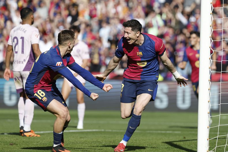 Robert Lewandowski (derecha) celebra con Fermín López tras anotar un gol para el Barcelona en el partido contra Girona en la Liga española, el domingo 30 de marzo de 2025, en Barcelona. (AP Foto/Joan Monfort)