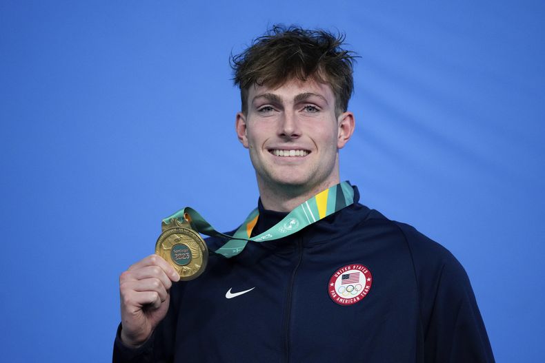 El estadounidense Jack Aikins posa con su medalla de oro en el podio de los 200 metros espalda de la natación de los Juegos Panamericanos en Santiago, Chile, el domingo 22 de octubre de 2023. (AP Foto/Silvia Izquierdo)