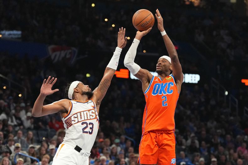 Shai Gilgeous-Alexander, del Thunder de Oklahoma City, dispara frente a Jordan Goodwin, de los Suns de Phoenix, en el duelo de la Copa NBA, realizado el viernes 28 de noviembre de 2025 (AP Foto/Kyle Phillips)