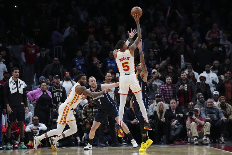 Dejounte Murray (5) de los Hawks de Atlanta, acierta el tiro de la victoria mientas el tiempo expiraba en el juego de baloncesto de la NBA en contra del Magic de Orlando, el miércoles 17 de enero de 2024, en Atlanta. (AP Foto/John Bazemore)