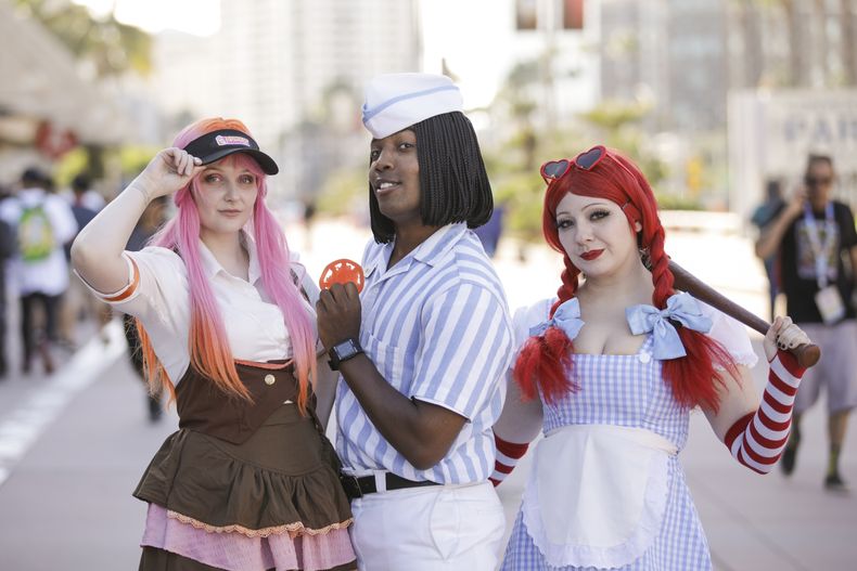 Diana, de izquierda a derecha, Kal Smith y Melissa Ann de San Diego, California, posan durante la noche de vista previa de la Comic-Con International el miércoles 23 de julio de 2025, en San Diego. (Foto Andrew Park/Invision/AP)