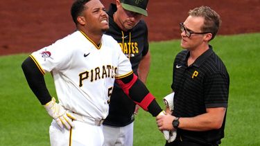 El mánager de los Piratas de Pittsburgh Don Kelly con el pelotero dominicano Esmerlyn Valdez mientras es examinado por el médico tras golpeado por una bola de Merrill Kelly de los Diamondbacks de Arizona el lunes 27 de julio del 2026. (AP Foto/Gene J. Puskar)