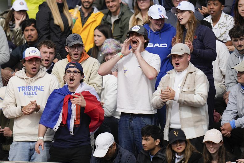 Aficionados al tenis gritan durante un partido de segunda ronda del torneo de tenis Abierto de Francia en Roland Garros, el jueves 30 de mayo de 2024. Un jugador dijo que un espectador le arrojó un chicle. Otra, Iga Swiatek, número uno del ranking, reprendió a la multitud en el estadio principal por hacer demasiado ruido durante los puntos. Así que el torneo de Grand Slam decidió que ya era suficiente: a partir del jueves los aficionados tienen prohibido beber alcohol en las gradas. (Foto AP/Thibault Camus)