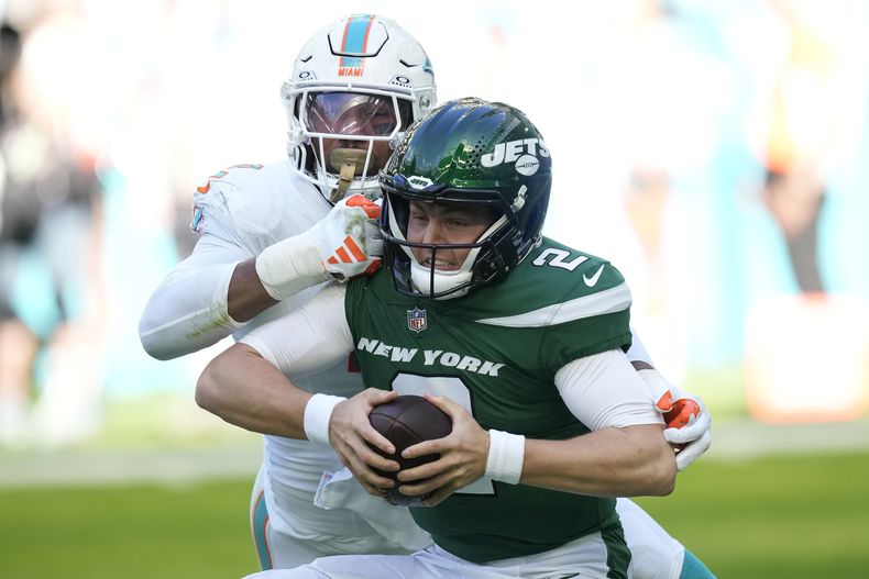Zach Wilson (2), quarterback de los Jets de Nueva York, es capturado por el linebacker de los Dolphins de Miami Bradley Chubb (2) durante la primera mitad del juego de la NFL, el domingo 17 de diciembre de 2023, en Miami Gardens, Florida. (AP Foto/Rebecca Blackwell)