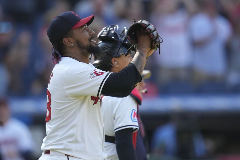 El cerrador dominicano de los Guardianes de Cleveland, Emmanuel Clase (izquierda), celebrea luego de que su equipo derrotara a los Rays de Tampa Bay, en el juego de béisbol el domingo 15 de septiembre de 2024, en Cleveland. (AP Foto/Sue Ogrocki)
