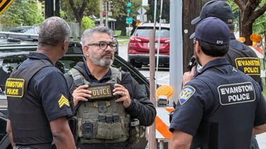 Esta foto, proporcionada por Ryan Garton, muestra a un agente federal hablando con policías el domingo 20 de septiembre de 2026, en Evanston, Illinois. (Ryan Garton vía AP)