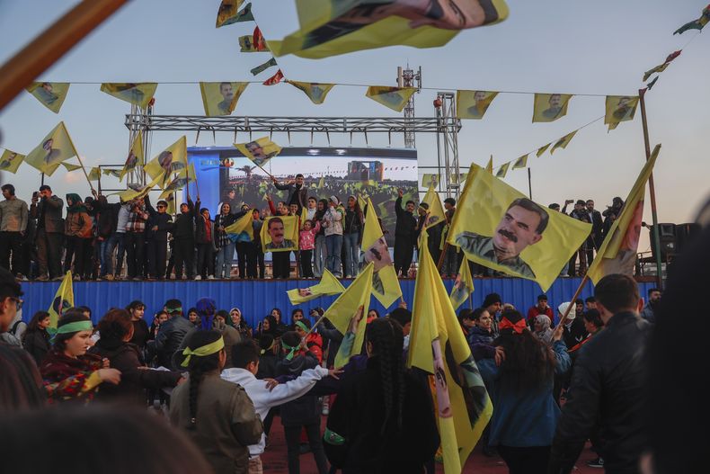 Residentes kurdos ondean banderas con el rostro de Abdullah Ocalan durante un acto para ver en directo a los miembros de la delegación del Partido Popular por la Igualdad y la Democracia, una formación prokurda, que publican una declaración encarcelado líder del Partido de los Trabajadores del Kurdistán, o PKK, en Qamishli, en el noreste de Siria, el 27 de febrero de 2025. (AP Foto/Baderkhan Ahmad)