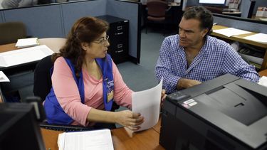 americateve | En esta foto del 6 de febrero de 2014, Rose Capote-Marcus, izquierda, ayuda a Waldemar Vega, de 50 a&ntilde;os, con tr&aacute;mites para recibir prestaciones por desempleo. El n&uacute;mero de personas que solicit&oacute; prestaciones aument&oacute; en 8.