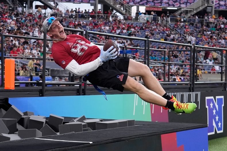 ARCHIVO - El ala cerrada Trey McBride de los Cardinals de Arizona celebra su touchdown saltando en una piscina de espuma durante el juego de fútbol americano Pro Bowl de la NFL, el 2 de febrero de 2025, en Orlando, Florida. (AP Photo/John Raoux, Archivo)
