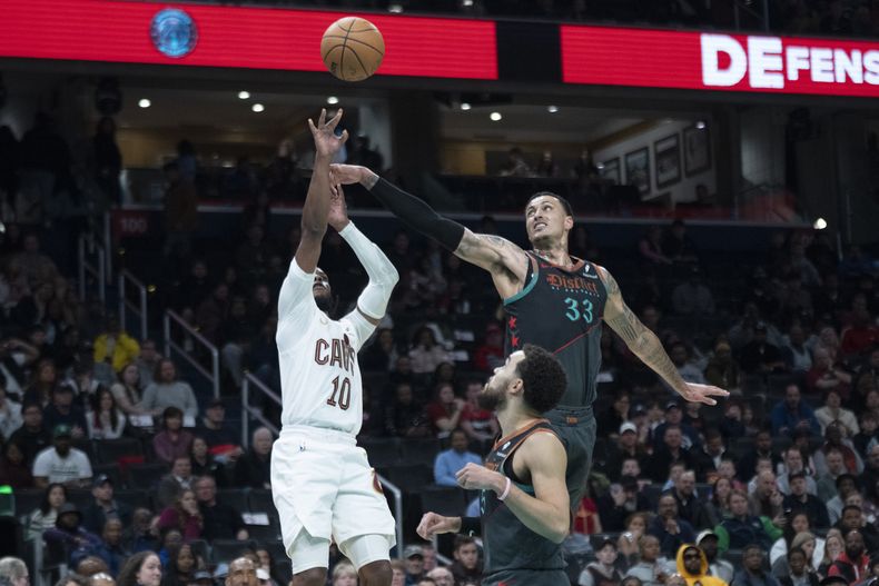 El alero de los Wizards de Washington Kyle Kuzma intenta bloquear el tiro del base de los Cavaliers de Cleveland Darius Garland en el encuentro de la NBA del domingo 25 de febrero del 2024. (AP Foto/Manuel Balce Ceneta)