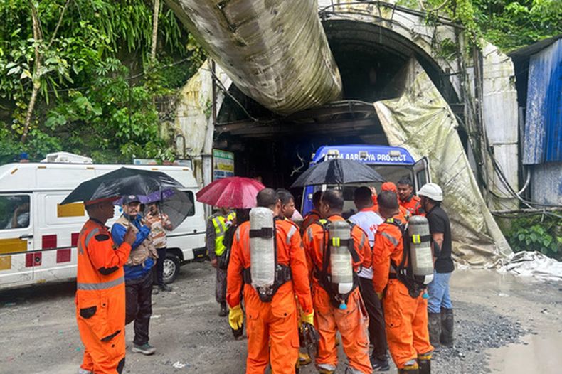 Miembros del equipo de rescate con bombonas de oxígeno ante un túnel de construcción en un proyecto hidroeléctrico en el pueblo de Samardung, unos 40 kilómetros (25 millas) de Gangtok, India, el martes 21 de julio de 2026. (AP Foto)